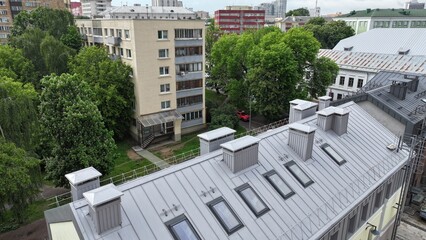 A modern low-rise office building with dormers on a pitched roof for natural sunlight. Contemporary eco-friendly office architecture. © Aerial Drone Master