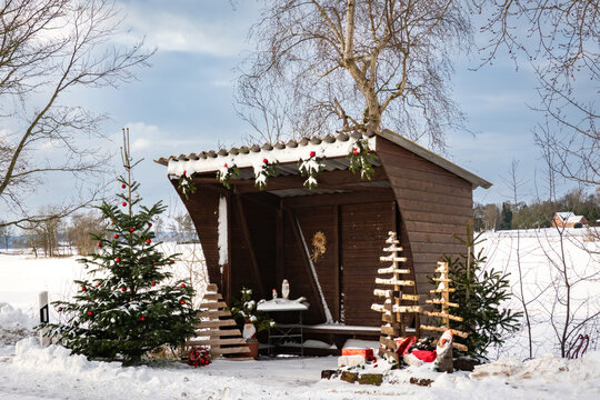 Winterlandschaften - verschneite und weihnachtlich dekorierte Bushaltestelle auf dem Lande.