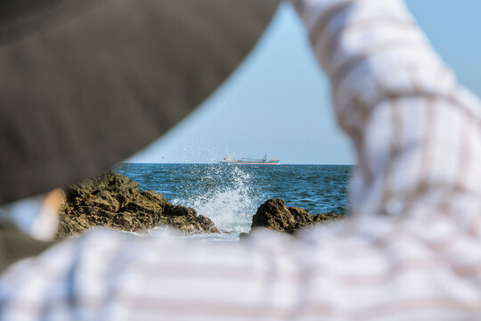 Ship sailing in the waves and a gaze from the shore.
