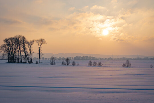 Sch&ouml;ner, goldiger Sonnenuntergang mit tiefverschneiter Winterlandschaft, Symbolfoto.