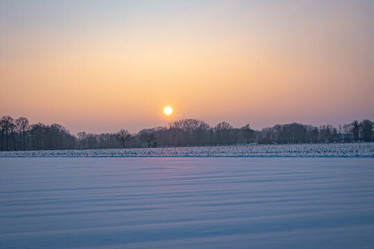 Sch&ouml;ner, goldiger Sonnenuntergang mit tiefverschneiter Winterlandschaft, Symbolfoto.