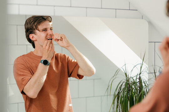 A man flosses his teeth