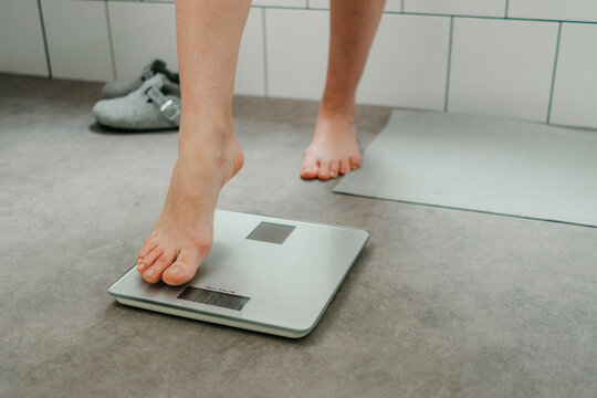The woman is weighing herself
