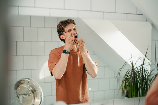 A man flosses his teeth