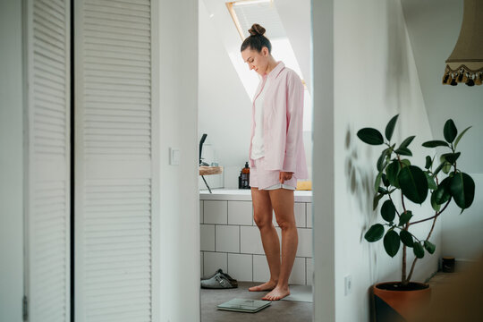 The woman is weighing herself