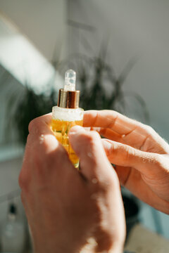 A man holds a bottle of cosmetic lotion in his hands