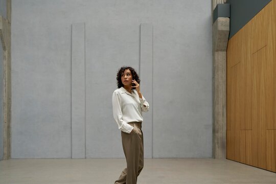 Woman in Modern Interior Speaks on a Phone in a Minimalist Space