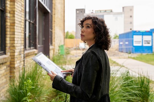 Curious Woman Examines Plans for Urban Development Project