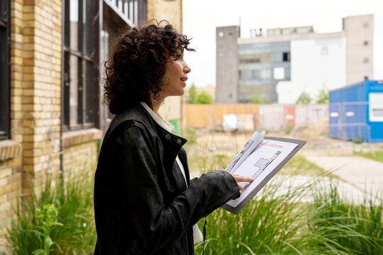 Woman Evaluating Plans in Urban Construction Setting