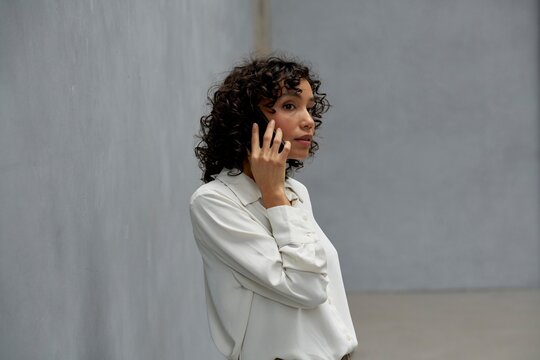Woman Engaged in a Phone Conversation in a Minimalist Interior