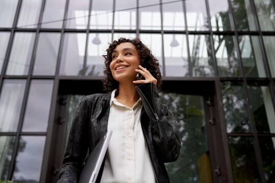 Businesswoman Making a Phone Call Outside a Modern Office Building