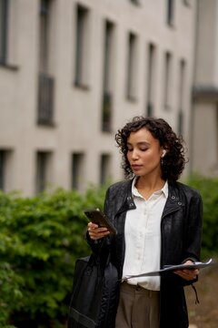 Businesswoman Walking Outside While Using Smartphone in the City