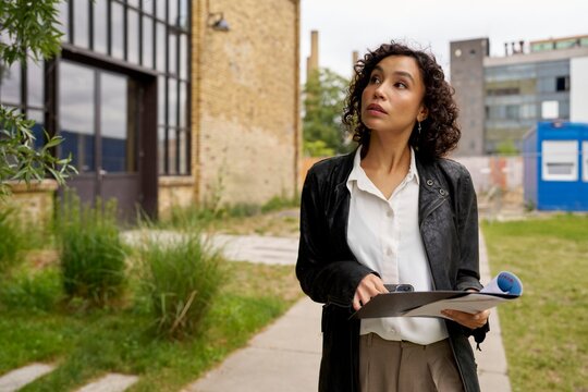 Professional Woman Assessing Site Conditions in Urban Setting