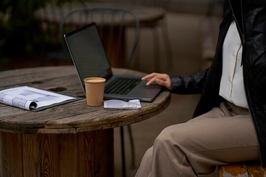 Working on a Laptop at an Outdoor Cafe Table in the Afternoon