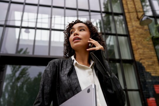 Professional woman chatting outside a modern upscale building 