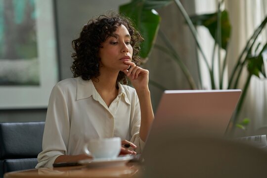 Focused Woman Working on Laptop in Modern Workspace