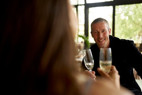 Smiling Man and Woman Sharing a Toast in a Modern Cafe