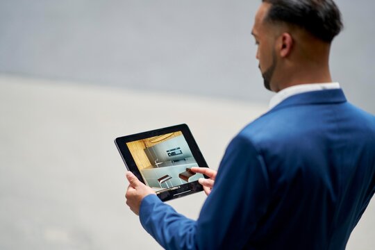 Businessman reviewing design expose on tablet in modern space