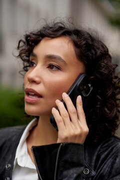 Woman Talking on Smartphone in Urban Setting During Daytime