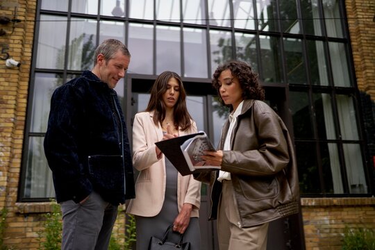 Professionals discussing plans outside a modern building