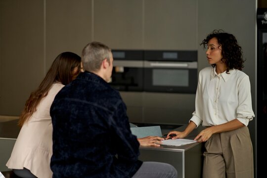 Couple discusses real estate plans with professional at modern office
