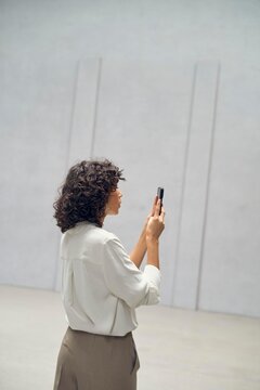 Curly-haired Woman Taking Picture in Modern empty property