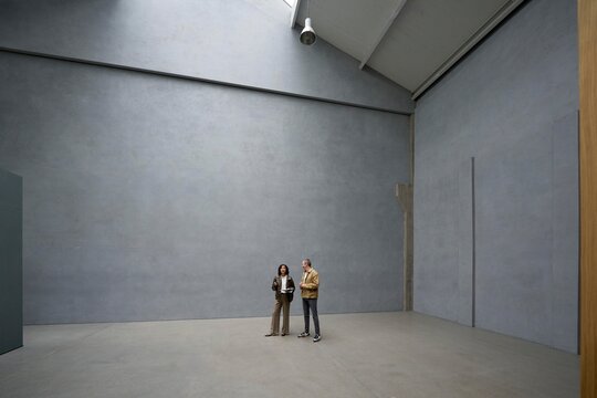 Visitors admire a roomy apartment with gray walls