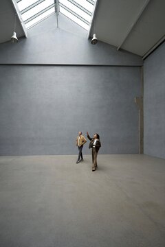 Visitors explore an empty apartment with skylights