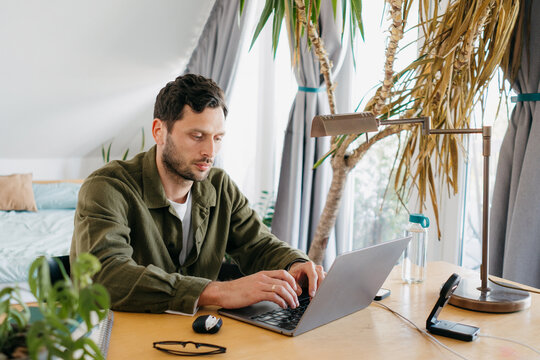 A man uses a laptop at home
