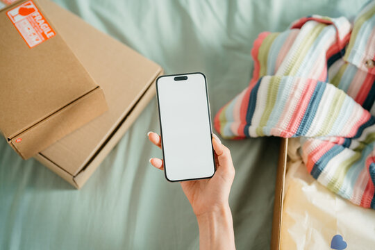 A woman's hand with a mobile phone with white screen