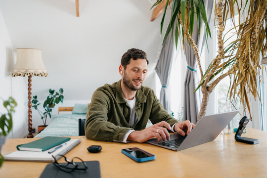 A man uses a laptop at home