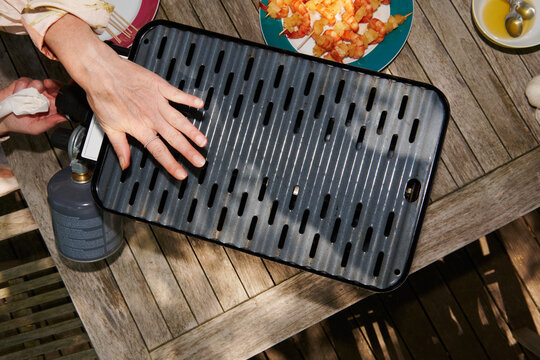 Woman Checking Heat on Tabletop Grill