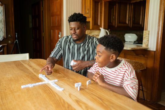 Father and son enjoying a game of dominoes at home