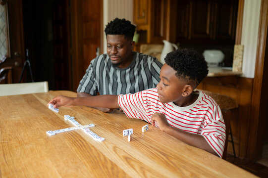 Father and son enjoying a game of dominoes at home