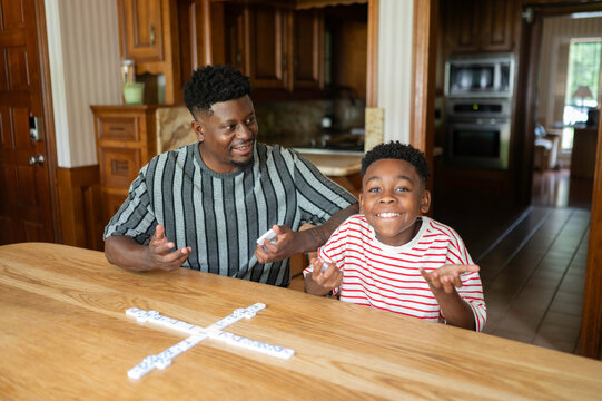 Father and son enjoying a game of dominoes at home
