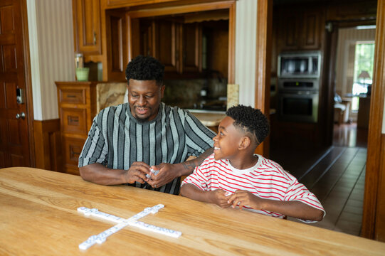 Father and son enjoying a game of dominoes at home