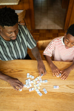 Father and son enjoying a game of dominoes at home