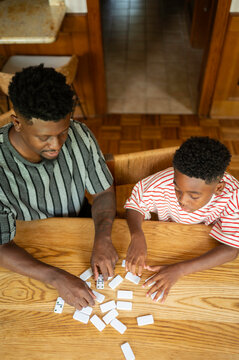Father and son enjoying a game of dominoes at home