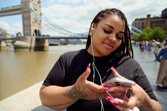 Woman Checking Phone with Tower Bridge in the Background