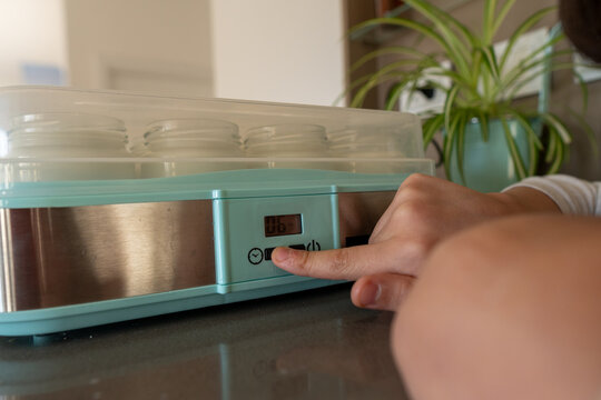 User Adjusting Temperature on Yogurt Maker in Modern Kitchen