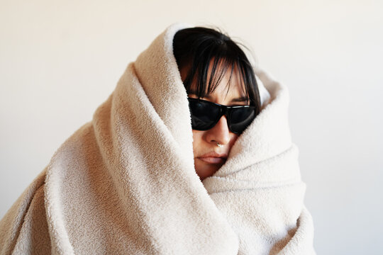 Resting woman in cozy setting, wrapped in textured blankets