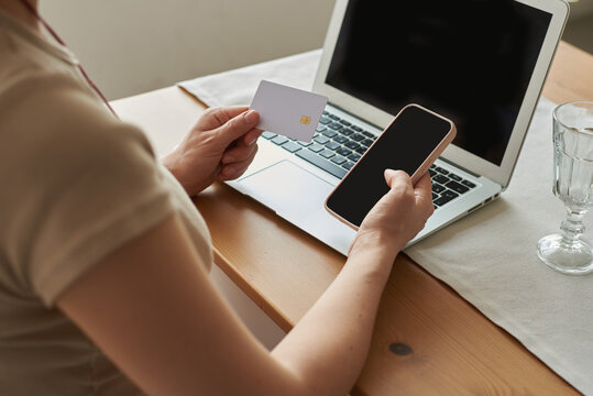 Person making online payment using smartphone and credit card at home