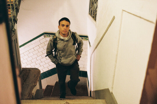 Teen Walking up Stairs in Building Hallway