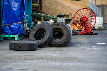 Old used tires and maritime equipment stored in an industrial yard near the harbor © Oleksandr Kashcheiev