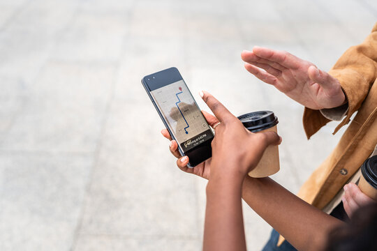 Tourists using gps app on smartphone and drinking coffee