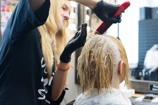A Hairdresser Dyes And Tones The Hair Of A Woman
