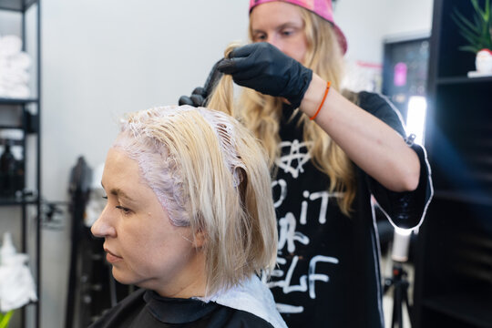 A Hairdresser Dyes And Tones The Hair Of A Woman