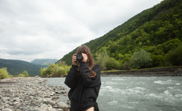 A girl with a camera at the river 