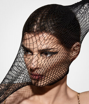 Woman Wearing Black Fishnet Over Her Face in Studio Portrait