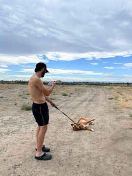 Man films playful Dog on a Path lying down During Outdoor Adventure